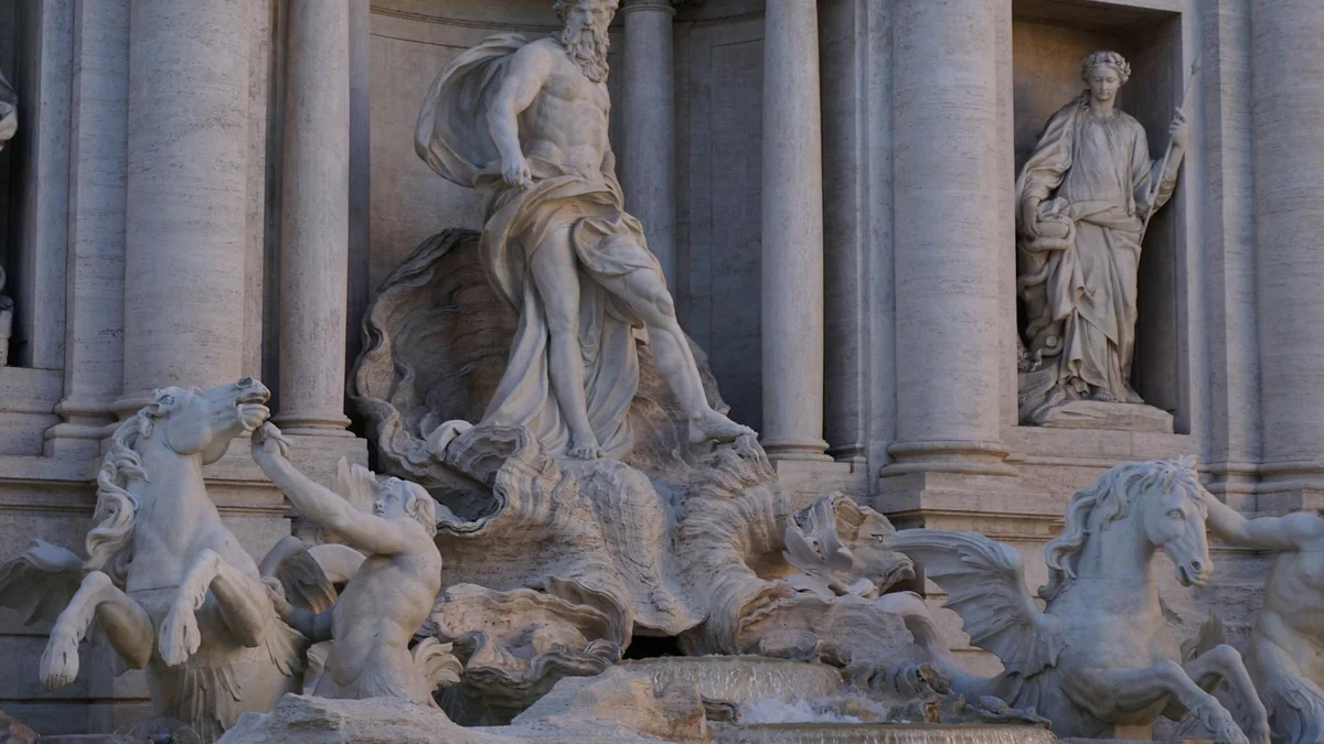 Fontana di Trevi iluminada con turistas tirando monedas Roma